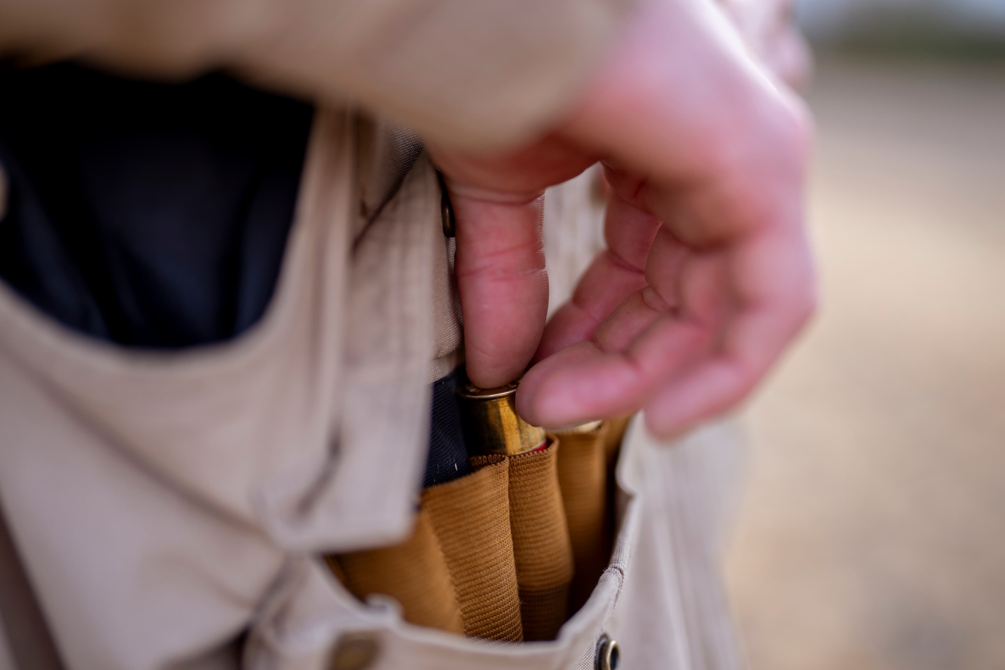 Hunter loading shells from vest pocket