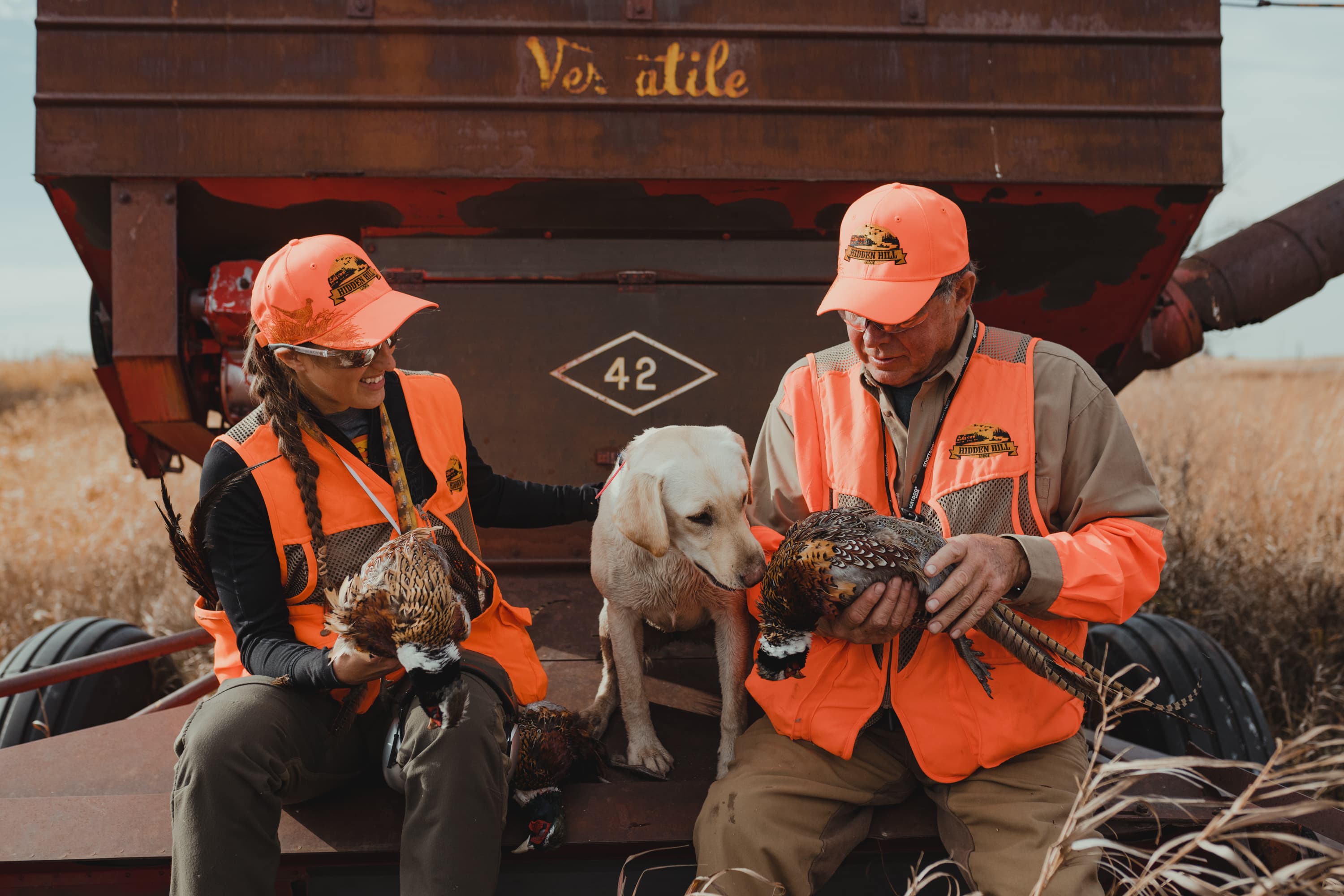 Hunters seated indoors in blaze orange gear